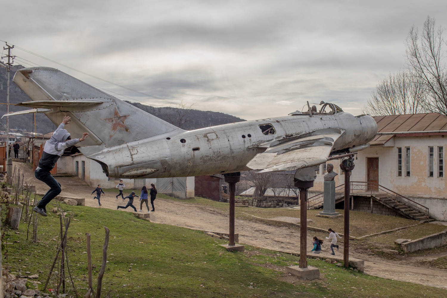 Kinder spielen und rennen um ein Flugzeug aus dem Zweiten Weltkrieg im Dorf Mets Tagher, Nagorno-Karabach 2020 aus der Serie Nagorno-Karabakh War and Exodus