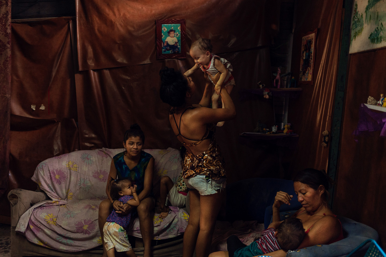 Grillis Febres (19, Mitte) und ihre Freundinnen spielen und kuscheln mit ihren Kindern, Caracas, Venezuela 2018 aus der Serie Paradise Lost